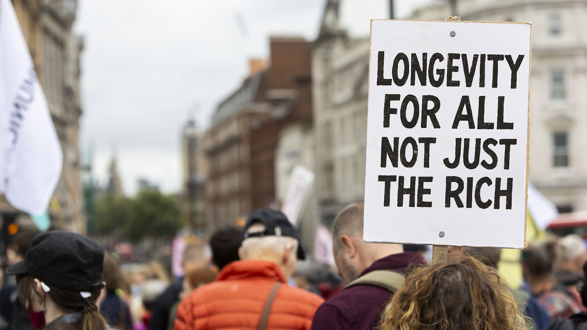 Protestors march with a banner reading ‘Longevity for all not just the rich’.
